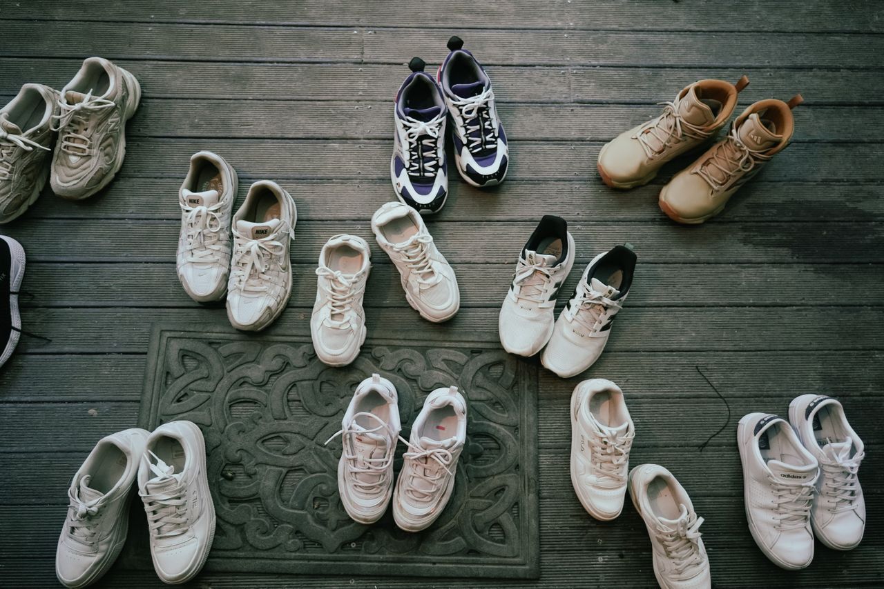 about-bg Various pairs of sneakers neatly laid out on a wooden deck, showcasing different styles.